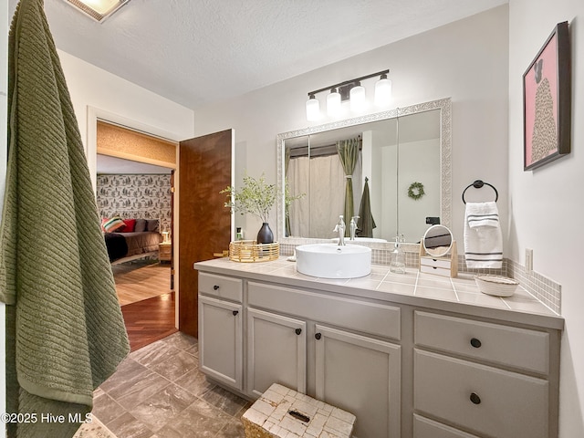 40 Inverness Rd, Pinehurst, NC 28374 - bathroom featuring vanity, marble look tile flooring, and a textured ceiling