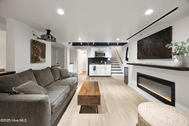 40 Inverness Rd, Pinehurst, NC 28374 - living area with light wood-type flooring, recessed lighting, a glass covered fireplace, and stairway