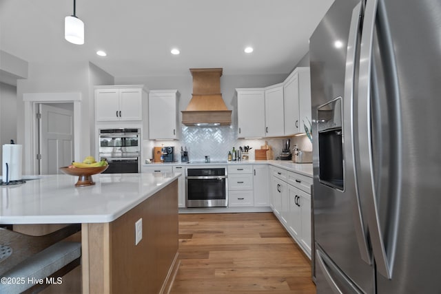 122 Back Creek Dr, Hertford, NC 27944 - kitchen featuring decorative backsplash, light countertops, premium range hood, stainless steel appliances, and white cabinetry