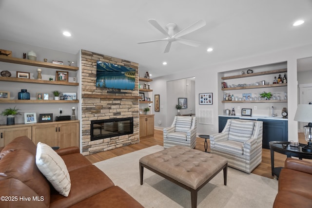 122 Back Creek Dr, Hertford, NC 27944 - living room featuring ceiling fan, light wood-style floors, a stone fireplace, indoor wet bar, and recessed lighting