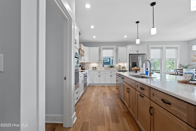 122 Back Creek Dr, Hertford, NC 27944 - kitchen with light wood-type flooring, light countertops, a sink, hanging light fixtures, and stainless steel appliances