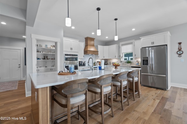 122 Back Creek Dr, Hertford, NC 27944 - kitchen with appliances with stainless steel finishes, light countertops, custom exhaust hood, light wood finished floors, and white cabinetry