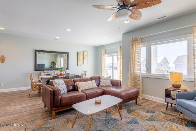 living room with ceiling fan, visible vents, wood finished floors, baseboards, and recessed lighting