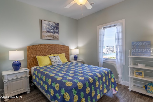 bedroom featuring visible vents, baseboards, ceiling fan, and wood finished floors