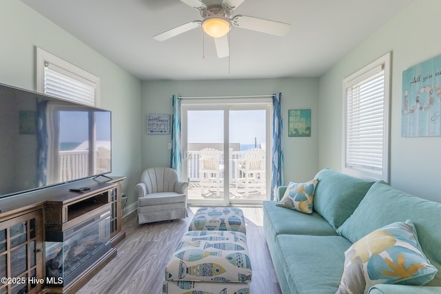 living room with a ceiling fan, baseboards, a wealth of natural light, and wood finished floors