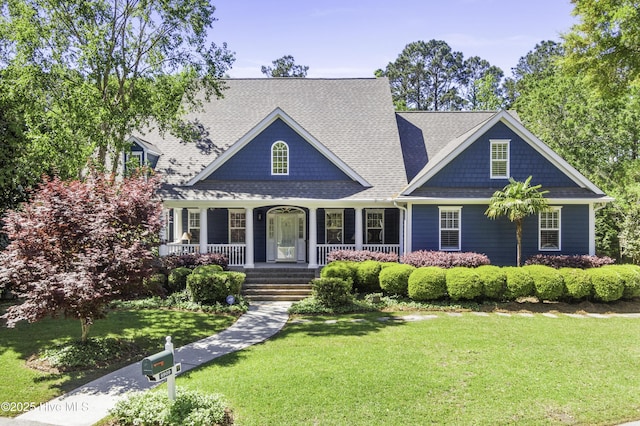 view of front facade with roof with shingles, a porch, and a front lawn