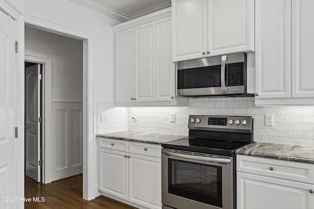 kitchen with backsplash, crown molding, appliances with stainless steel finishes, and white cabinetry