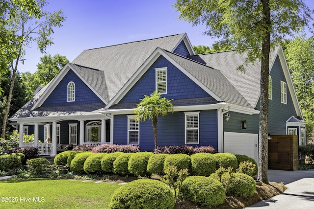 craftsman inspired home featuring a porch, a shingled roof, and a garage
