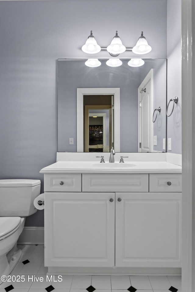 bathroom with tile patterned flooring, toilet, vanity, and baseboards
