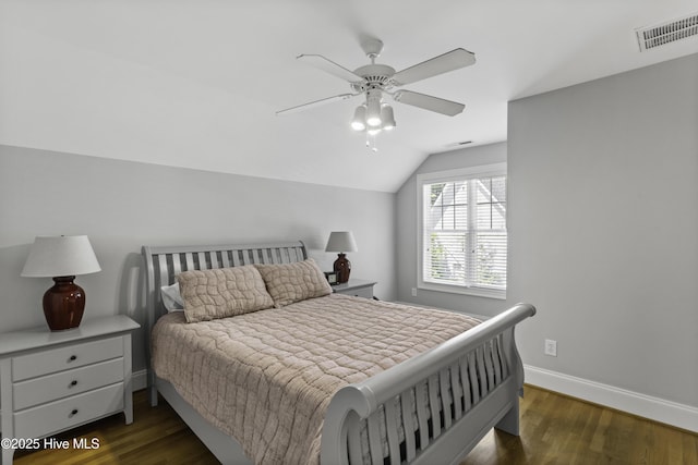 bedroom with lofted ceiling, wood finished floors, visible vents, and baseboards