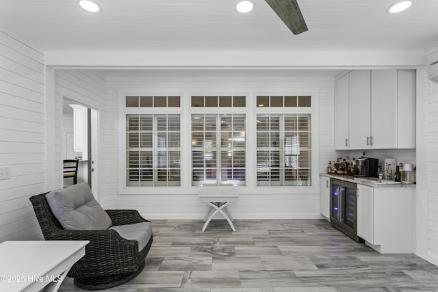 bar with recessed lighting, light wood finished floors, a bar, and wine cooler