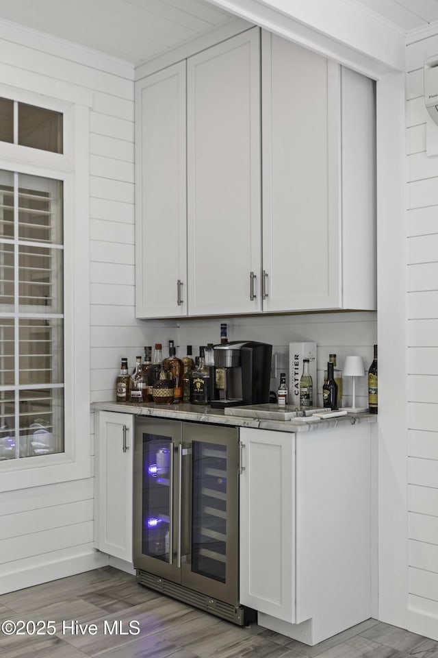 bar featuring a dry bar, light wood-style floors, and wine cooler