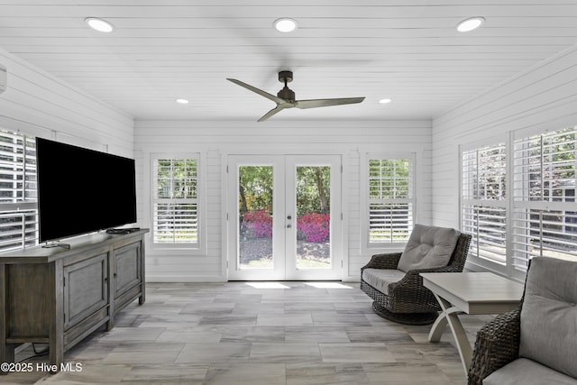 living room with a ceiling fan, french doors, wooden walls, and recessed lighting