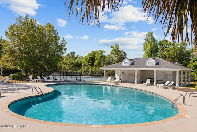 community pool with fence and a patio