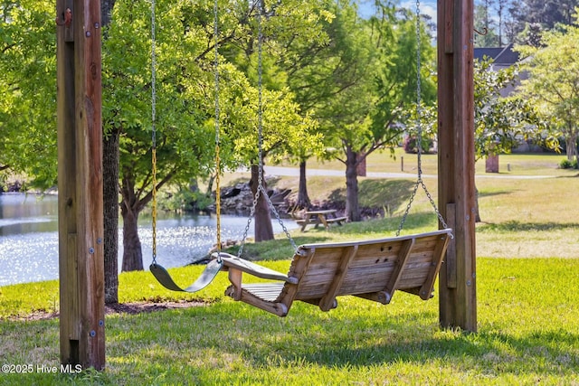 view of property's community with a lawn and a water view