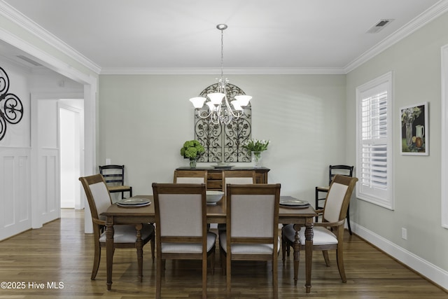 dining space with ornamental molding, a chandelier, wood finished floors, and visible vents