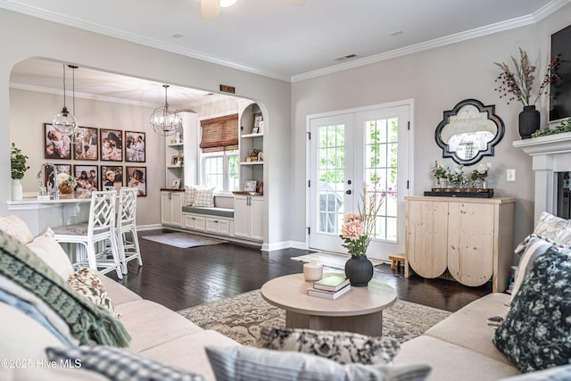 180 Cashew Loop, Cameron, NC 28326 - living room with crown molding, dark wood-style flooring, a glass covered fireplace, baseboards, and arched walkways
