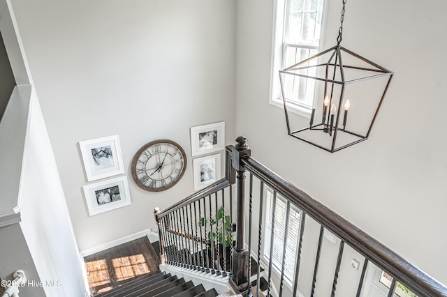 180 Cashew Loop, Cameron, NC 28326 - stairway featuring a chandelier, wood finished floors, and a towering ceiling