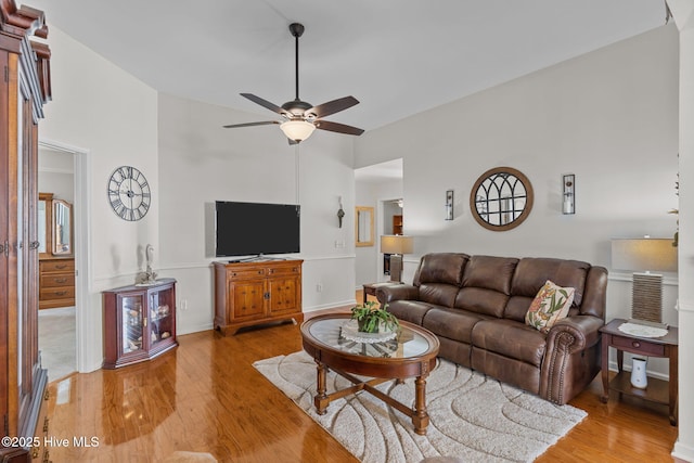 living room with ceiling fan, high vaulted ceiling, light wood finished floors, and baseboards
