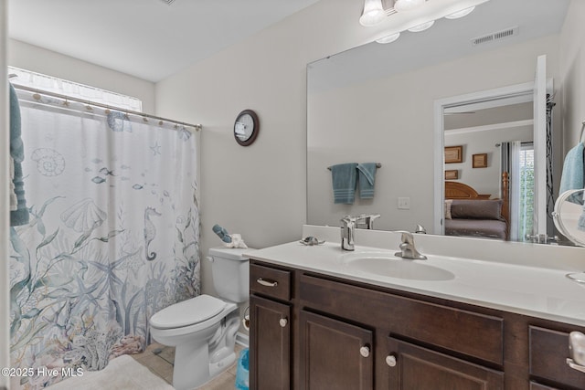ensuite bathroom with toilet, vanity, tile patterned floors, and a shower with curtain