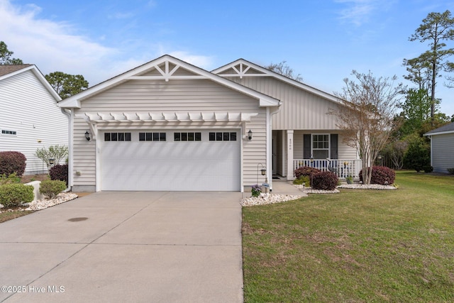 view of front of property with an attached garage, covered porch, driveway, and a front yard