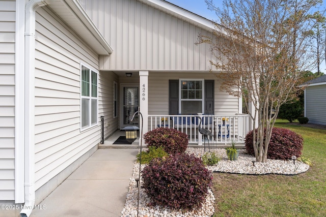 property entrance featuring a porch and a lawn