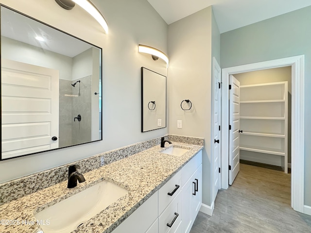 GEORGETOWN Spinnaker Dr, Elizabeth City, NC 27909 - bathroom featuring tiled shower, double vanity, a sink, and wood finished floors