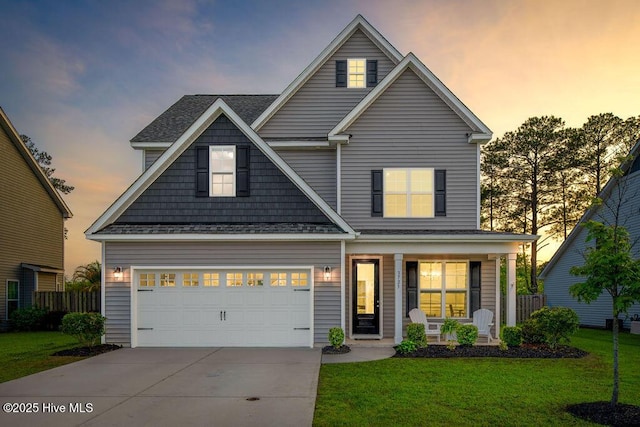 view of front of home featuring driveway, a porch, a front lawn, and a garage