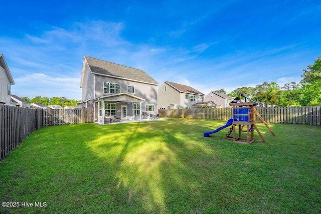 back of house featuring a fenced backyard, a patio area, a yard, and a playground