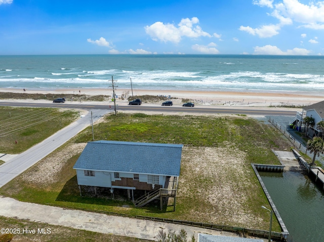 drone / aerial view featuring a beach view and a water view