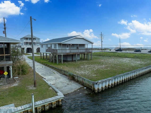 view of home's community with a lawn and a deck with water view