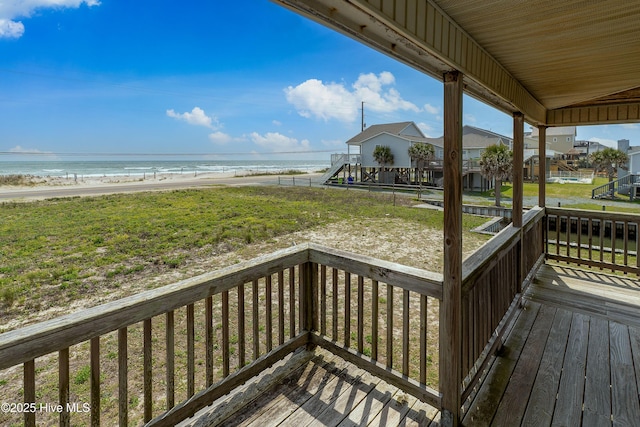 deck featuring a view of the beach and a water view