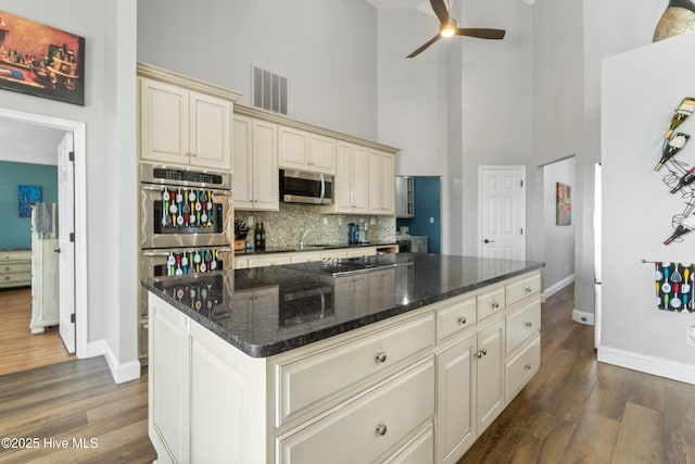 111 Waterway Ct, Aydlett, NC 27916 - kitchen with stainless steel appliances, baseboards, cream cabinetry, a towering ceiling, and visible vents