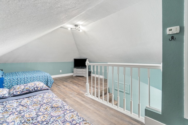 111 Waterway Ct, Aydlett, NC 27916 - bedroom featuring wood finished floors, baseboards, a textured ceiling, and lofted ceiling
