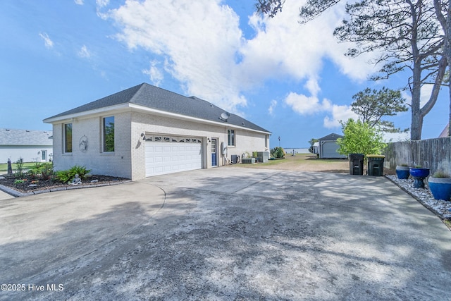 111 Waterway Ct, Aydlett, NC 27916 - view of home's exterior featuring a garage, fence, concrete driveway, and brick siding