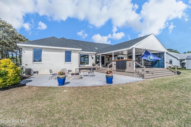 111 Waterway Ct, Aydlett, NC 27916 - back of property featuring a fire pit, brick siding, a shingled roof, a patio area, and a lawn