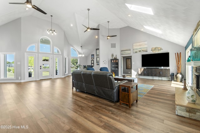 111 Waterway Ct, Aydlett, NC 27916 - living room featuring high vaulted ceiling, a fireplace with raised hearth, ceiling fan with notable chandelier, and wood finished floors