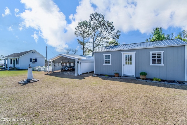111 Waterway Ct, Aydlett, NC 27916 - rear view of house featuring a lawn, a detached carport, an outbuilding, and metal roof