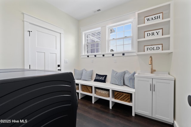 mudroom featuring visible vents, a sink, and dark wood-style floors