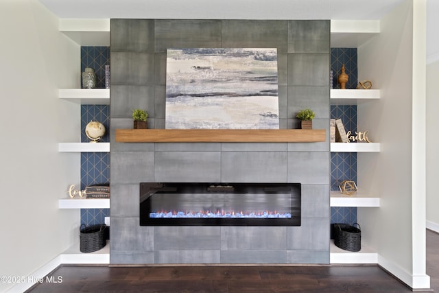 room details featuring wood finished floors, baseboards, and a tile fireplace
