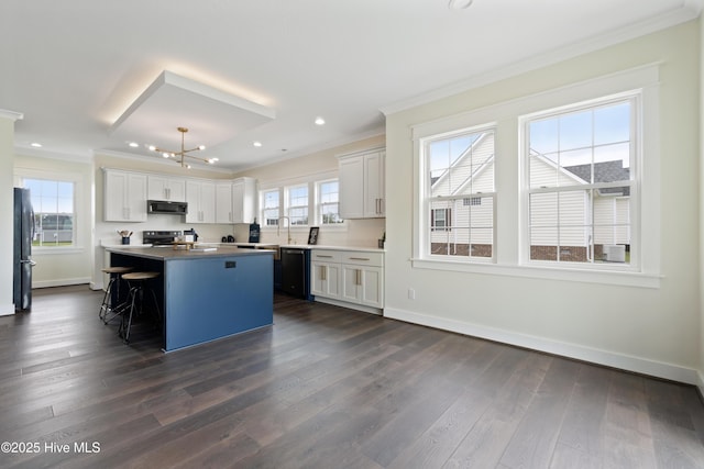 kitchen with black appliances, baseboards, crown molding, and a center island