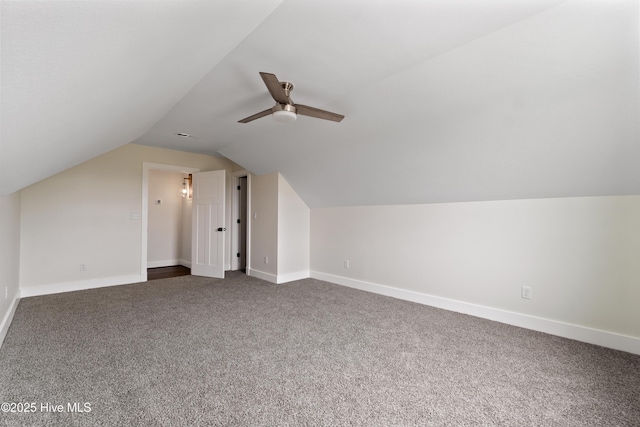 bonus room with dark carpet, ceiling fan, vaulted ceiling, and baseboards