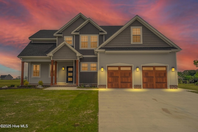 craftsman house featuring a porch, driveway, a front yard, and a garage