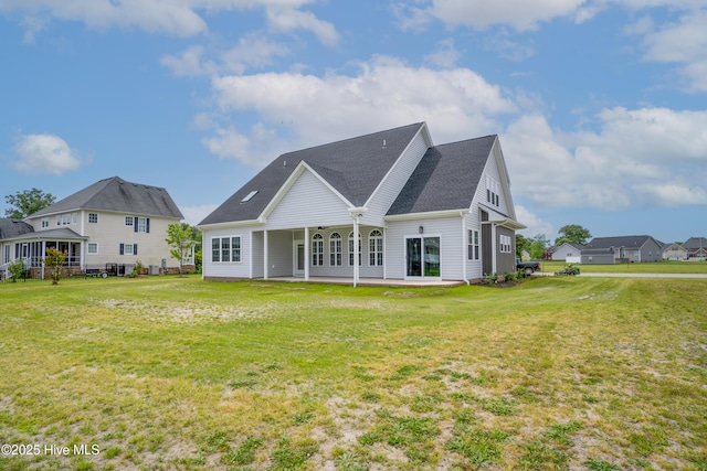 rear view of house featuring a yard and a patio