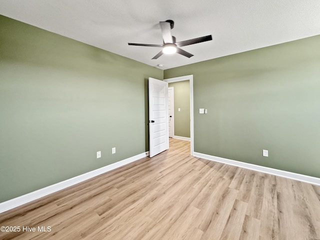 unfurnished bedroom with ceiling fan, baseboards, and light wood-style flooring
