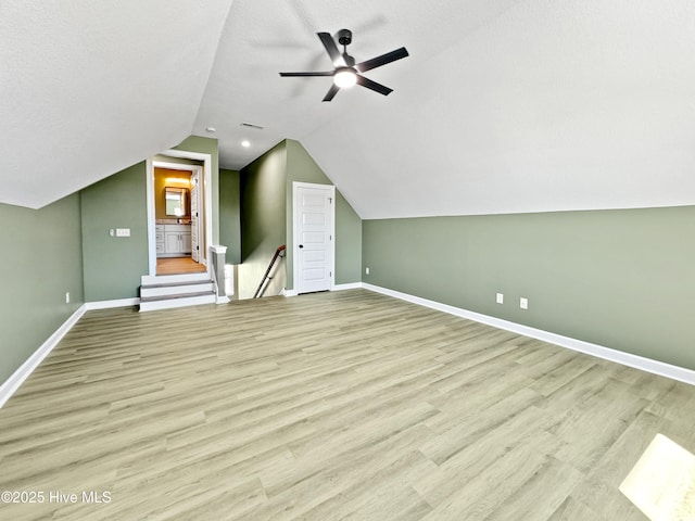 bonus room with vaulted ceiling, a ceiling fan, light wood finished floors, baseboards, and visible vents