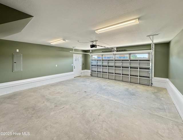 garage with electric panel and a garage door opener