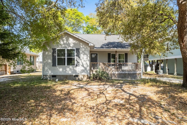 121 NW 19th St, Oak Island, NC 28465 - ranch-style house featuring cooling unit, a porch, crawl space, and a shingled roof