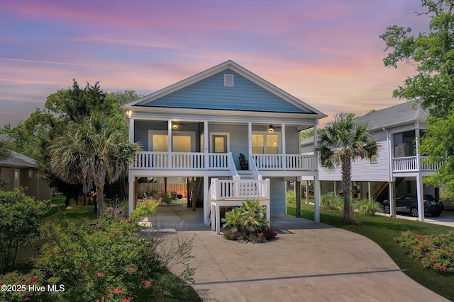 view of front of property featuring a carport, a ceiling fan, stairs, and concrete driveway