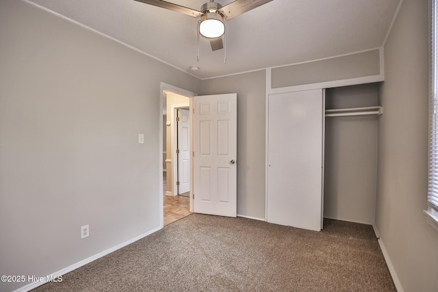 unfurnished bedroom with a ceiling fan, baseboards, carpet floors, and a closet